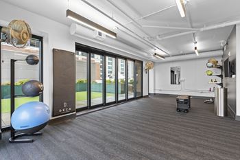A workout room with a yoga ball and other exercise equipment in front of a window